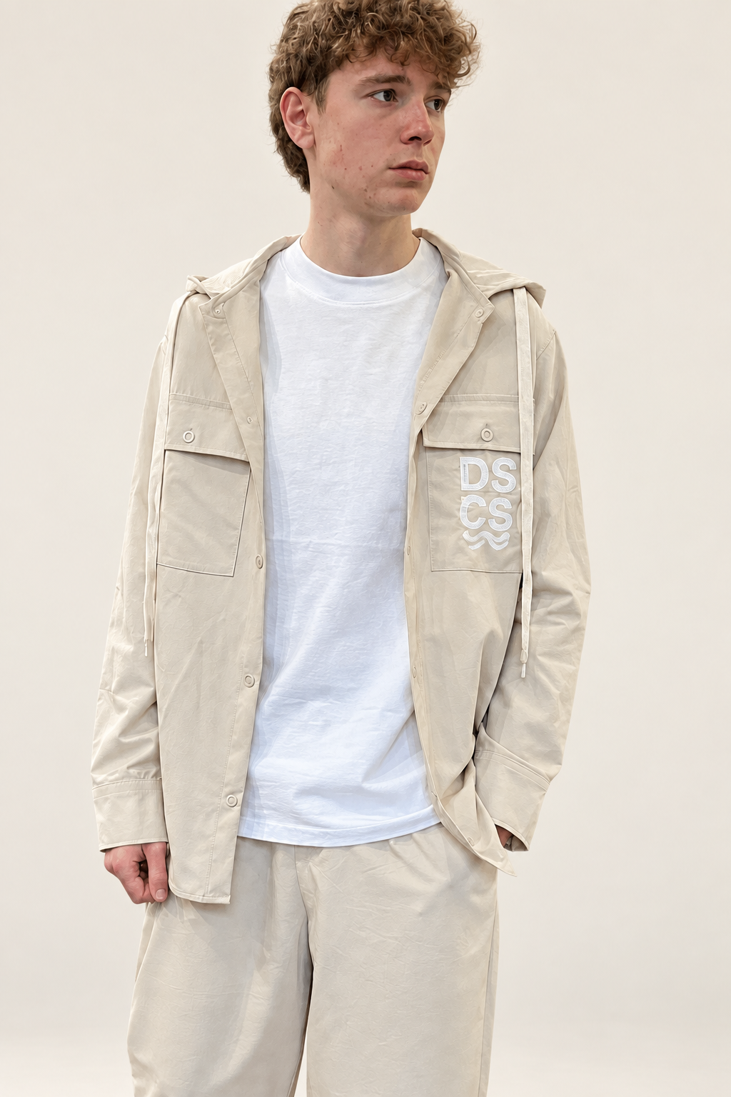 Modello con felpa DS2 beige chiaro su sfondo minimal