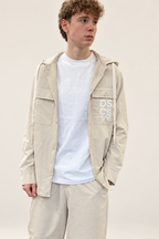 Modello con felpa DS2 beige chiaro su sfondo minimal